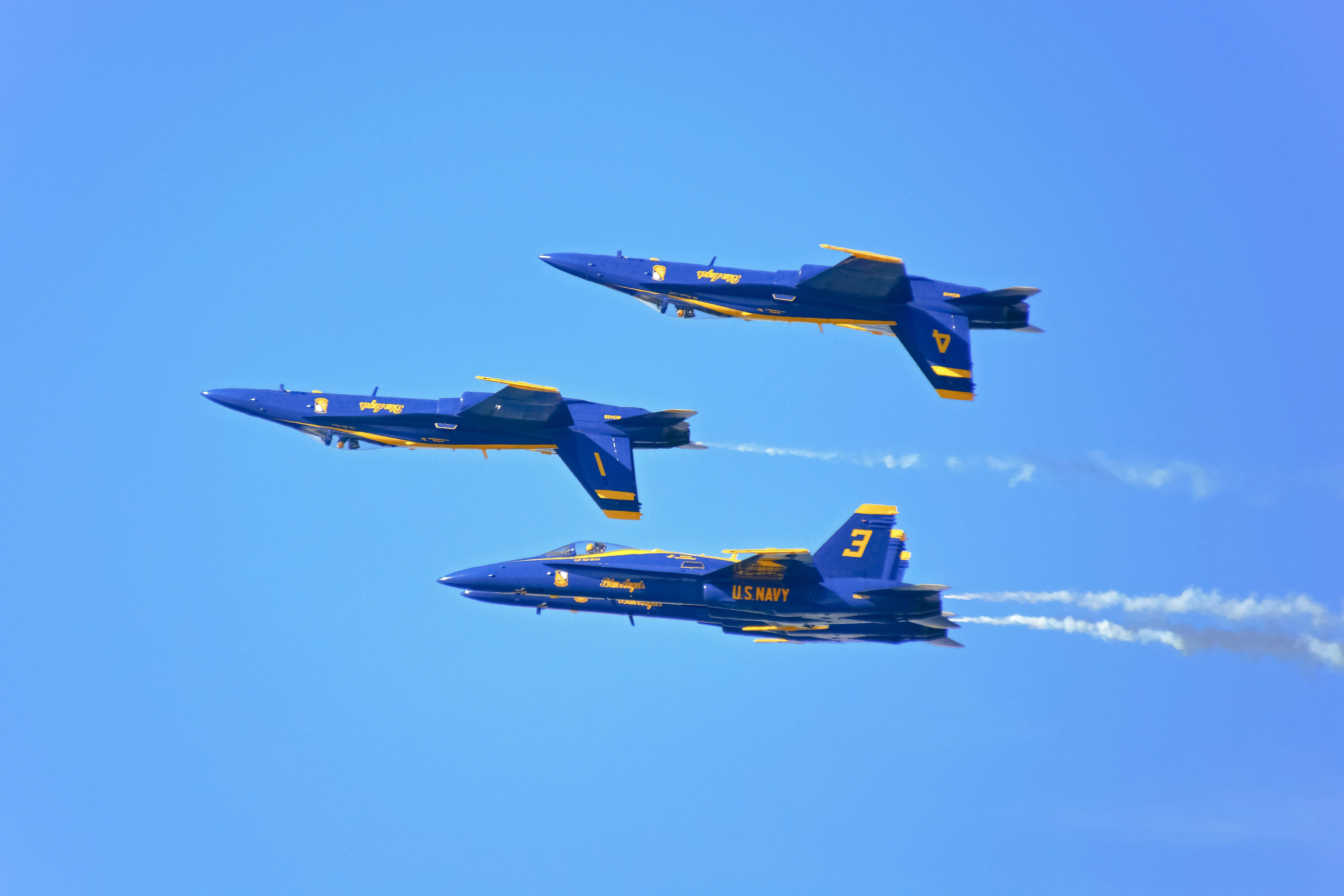 blue and yellow fighter plane in mid air during daytime